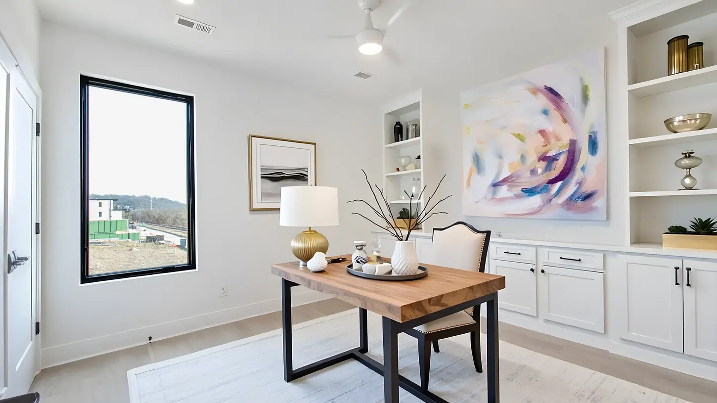 Modern empty flex room in Walworth Junction with large black-framed picture window, white walls, and light oak flooring built by Frazier Homes.