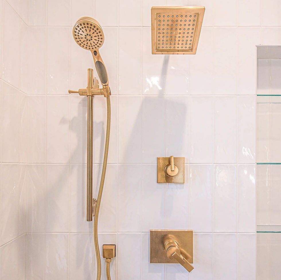 A stunning close-up of the Hyde Park master shower featuring modern gold fixtures that bring warmth and sophistication to the space. The clean white tile backdrop, rainfall showerhead, and sleek handheld design create a spa-inspired experience, perfectly blending luxury and functionality. Designed by Frazier Homes, this bathroom showcases the craftsmanship and attention to detail found in every Cincinnati custom home build.