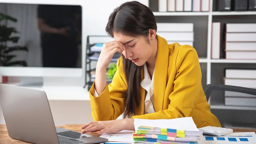 Homeowner reviewing documents at a desk, illustrating the stress of budgeting and decision-making during the custom home building process discussed in Learn the Difference Episode 21.