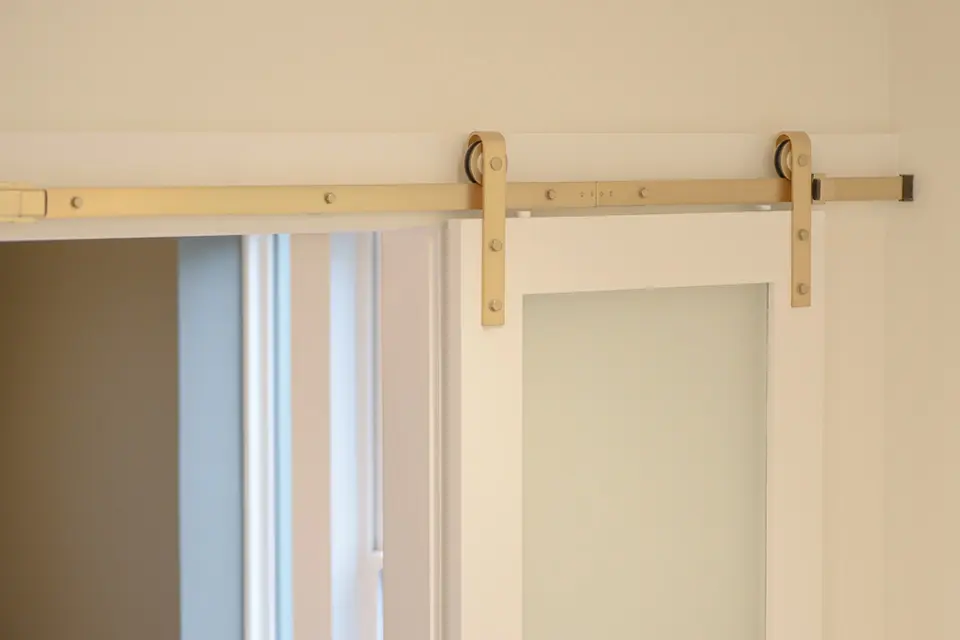 Brass sliding barn door hardware detail in a Hyde Park Cincinnati home remodel with modern interior finishes by Frazier Homes.