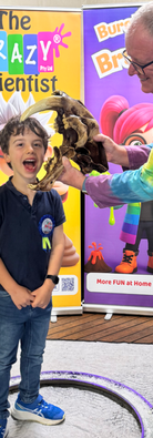 Child with sabre-tooth tiger skull during The Crazy Scientist’s giant bubble experiment at STEM birthday party.