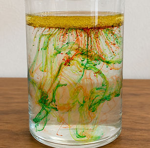 food colouring droplets streaming through water in comet-like trails — Comet Collisions science experiment for kids