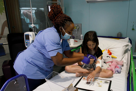 A young patient choosing flowers to be included in the Bedside Florilegium mobile lightbox, Great Ormond Street Hospita