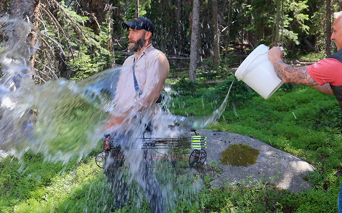 LORIS drenching fellow founder with a bucket of water during a fun outdoor moment showing the playful spirit behind the brand