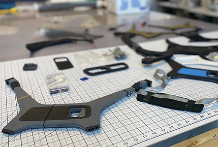 Disassembled parts of the Quick Release Sling spread across a table in the engineering lab, showcasing the meticulous design