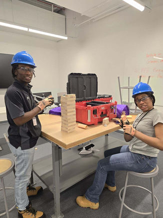 Students showing their construction work progress in the classroom