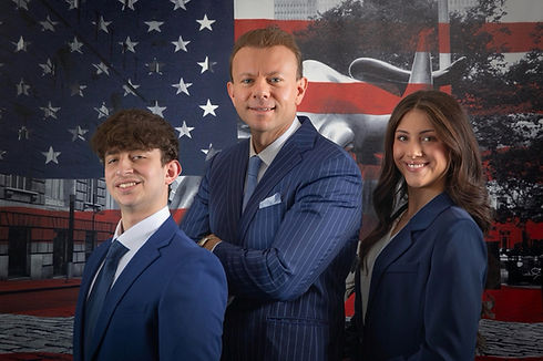 Mario, Eric and Alexis in front of an American flag