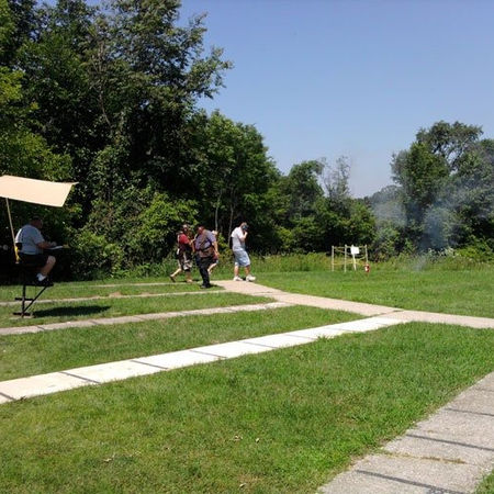 Outdoor shooting range with people on the lawn.
