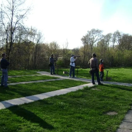 Group of people target shooting at an outdoor range.