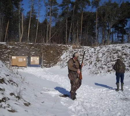 Shooters at an outdoor winter firing range in the snow.