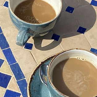 2 blauwe kopjes koffie op een wit tegelblad
