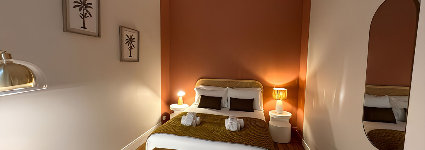 chambre à la décoration simple et pure avec mur complet peint en terracotta niveau tête de lit.