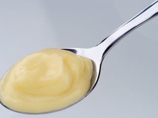 Spoonful of smooth vanilla custard on a silver spoon