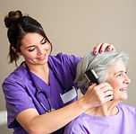 caregiver with purple scrubs brushing senior hair.jpg
