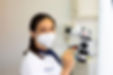 Médica dentista a usar o microscópio dentário para endodontia.