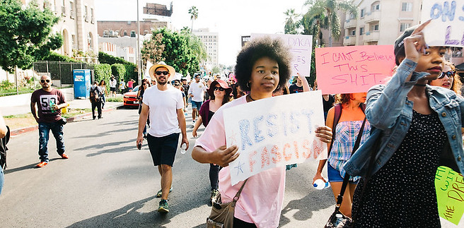 Protester with a sign that says "Resist fascism"