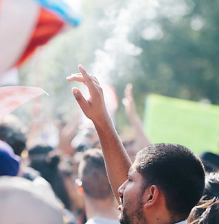 Man raising his hand with flag in the background