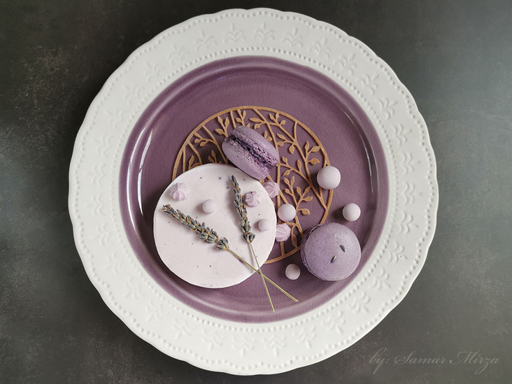 elegant lavender dessert plate with French macarons, delicate mousse cake topped with lavender sprigs, sugar spheres, and artistic golden lattice, styled with precision and balance