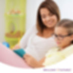 Parent helps child wearing glasses with homework.