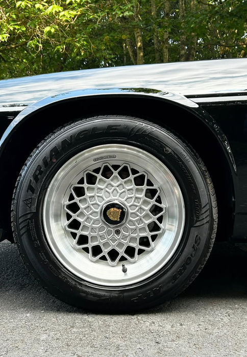 Classic Jaguar XJS alloy wheel with a flawless shine, reflecting professional rim detailing and tire conditioning.