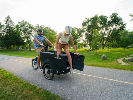 Woman opening the cargo bike door and stepping out.
