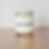 Glass jar candle with "UNIVERSITY CANDLE CO HOPKINS" label on wooden surface.