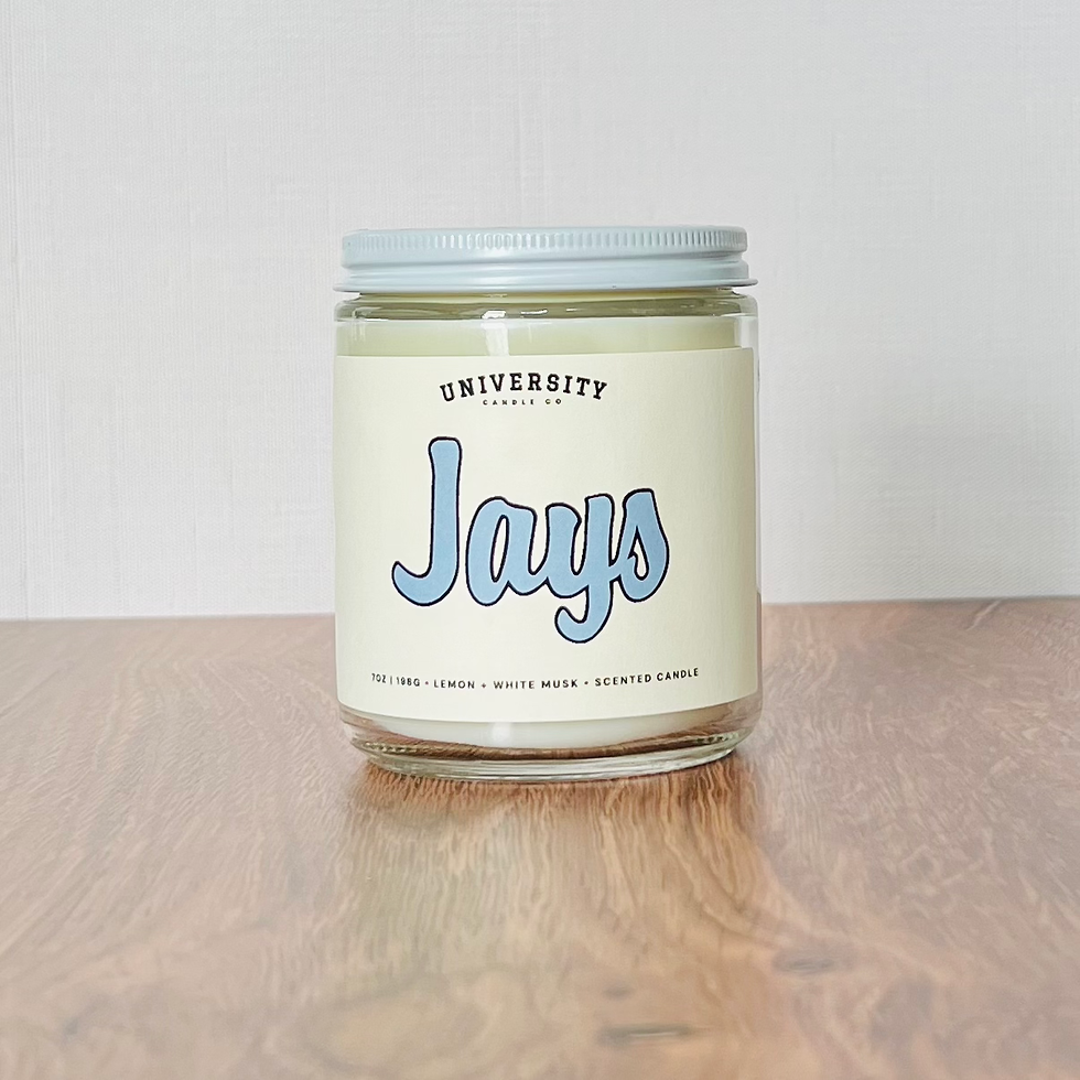 Glass jar candle with 'UNIVERSITY STUDIO CO. Jays' label.