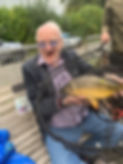 Fishing for care homes man holding a Mirror Carp