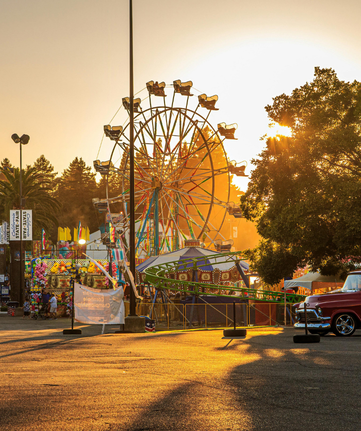 Ferris wheel and carnival rides at the Commercial Point Homecoming Festival in Commercial Point, Ohio during sunset