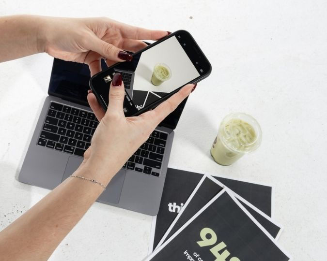 Taylo Studio creating social media content with a smartphone and laptop for digital marketing