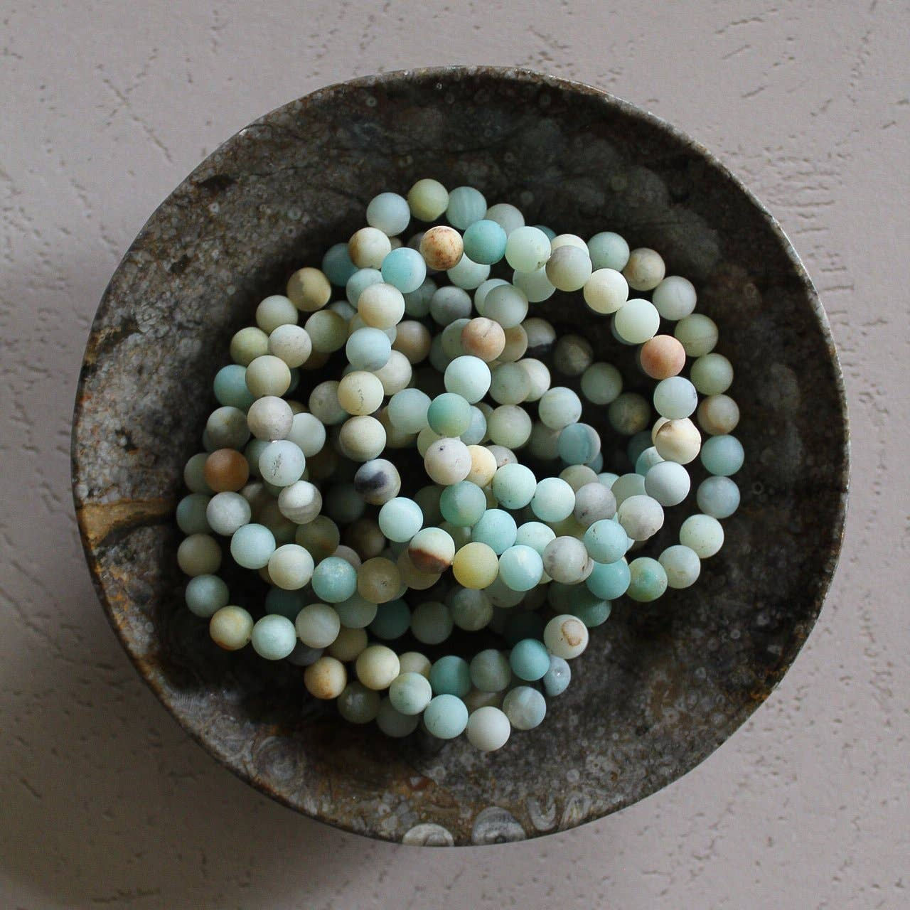 multiple amazonite crystal bracelets in a bowl