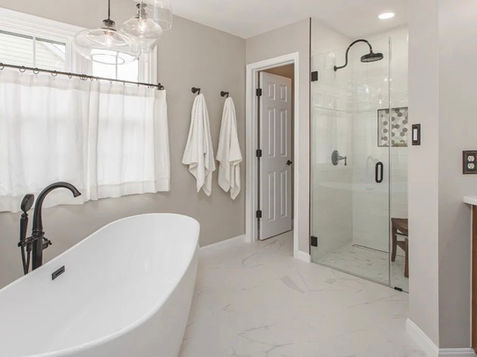 Elegant bathroom featuring a modern tub, glass shower, and Manning Building Company.
