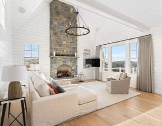 Living room with a stone fireplace and white walls