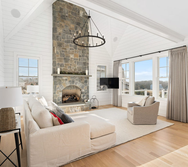 Living room with white walls, fireplace, sofa, and windows with a view.