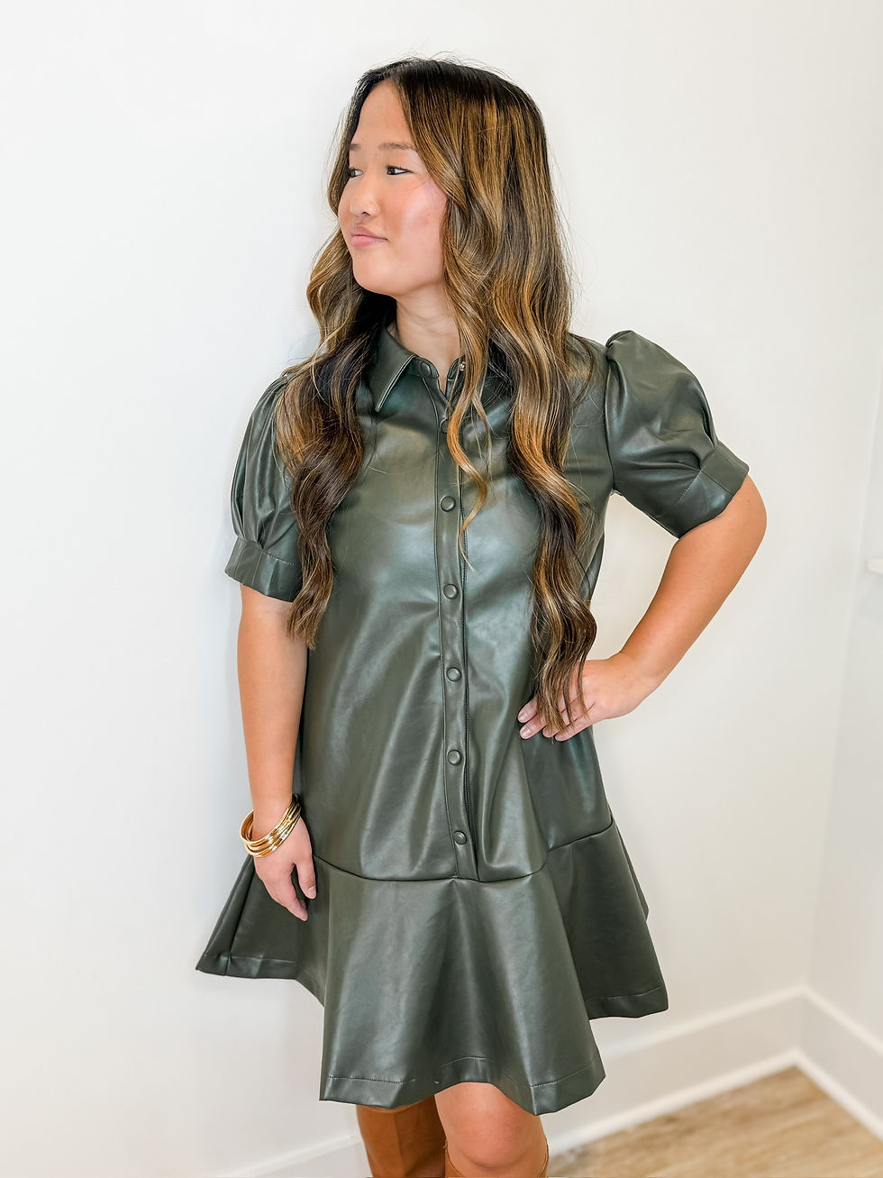 Elegant olive green leather dress styled for a formal occasion