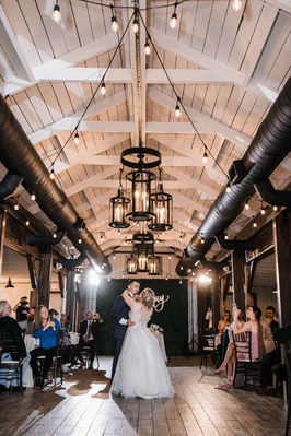 Elegant indoor wedding reception space at Windmill Winery Lake House in Phoenix, featuring high ceilings and rustic chandeliers.