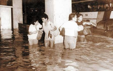 Pessoas andando na rua alagada em Petrópolis
