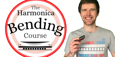 Smiling, caucasian man wearing a grey t-shirt, holding a harmonica against a white background with a circle graphic to his left that has a light and dark red border and the text 'the harmonica bending course', with a black and white graphic of a harmonica and the words 'module 1' in bold text written underneath.