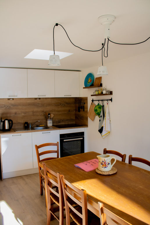 Photo d’une table à manger avec vue sur le jardin, créant un cadre agréable et lumineux pour les repas dans le gîte.