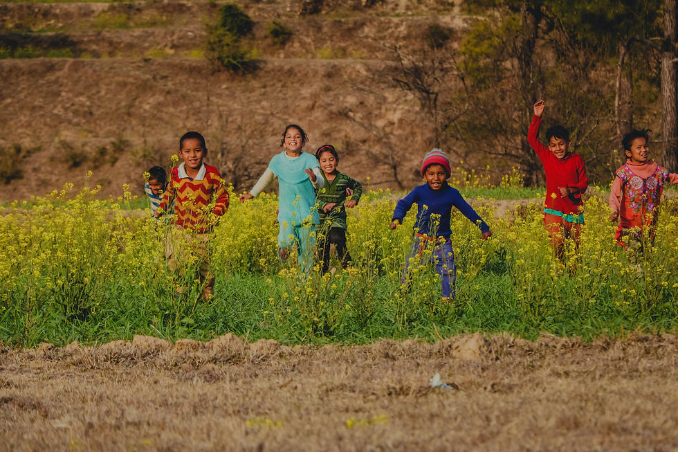Children playing joyfully in open green fields.