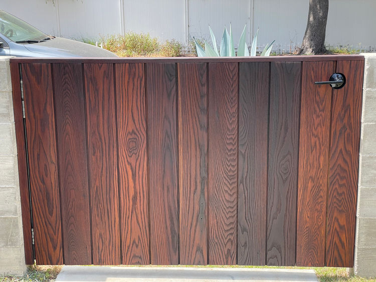 Stained red-toned gate completed by wood contractor near me.