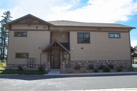 Fort Lauderdale home with tan siding, stone base, and white trim.