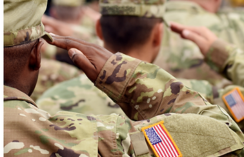 Soldiers standing in formation saluting the American flag.