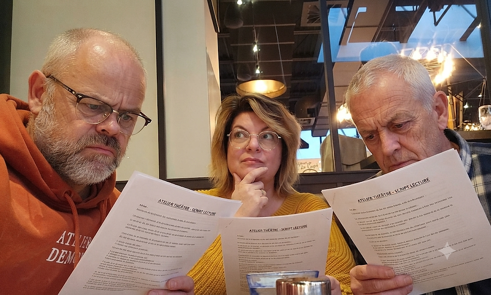 Trois personnes lisent des documents d'atelier théatre.