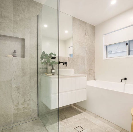 White and bright coastal renovation in Isle of Capri featuring oak flooring, black accents, natural stone tiles, and light-filled spaces for a fresh, modern coastal vibe.