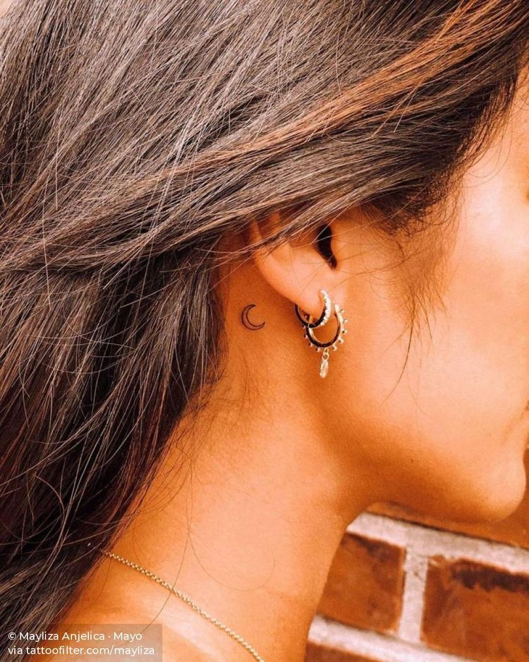 simple small moon tattoo behind womans ear