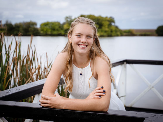 Portræt af konfirmand fotograferet på lille bro ved sø midt på Sjælland