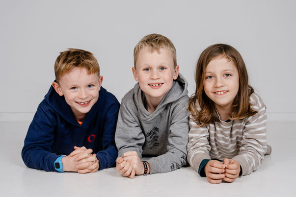 3 glade smilende drenge er fotograferet i studie.