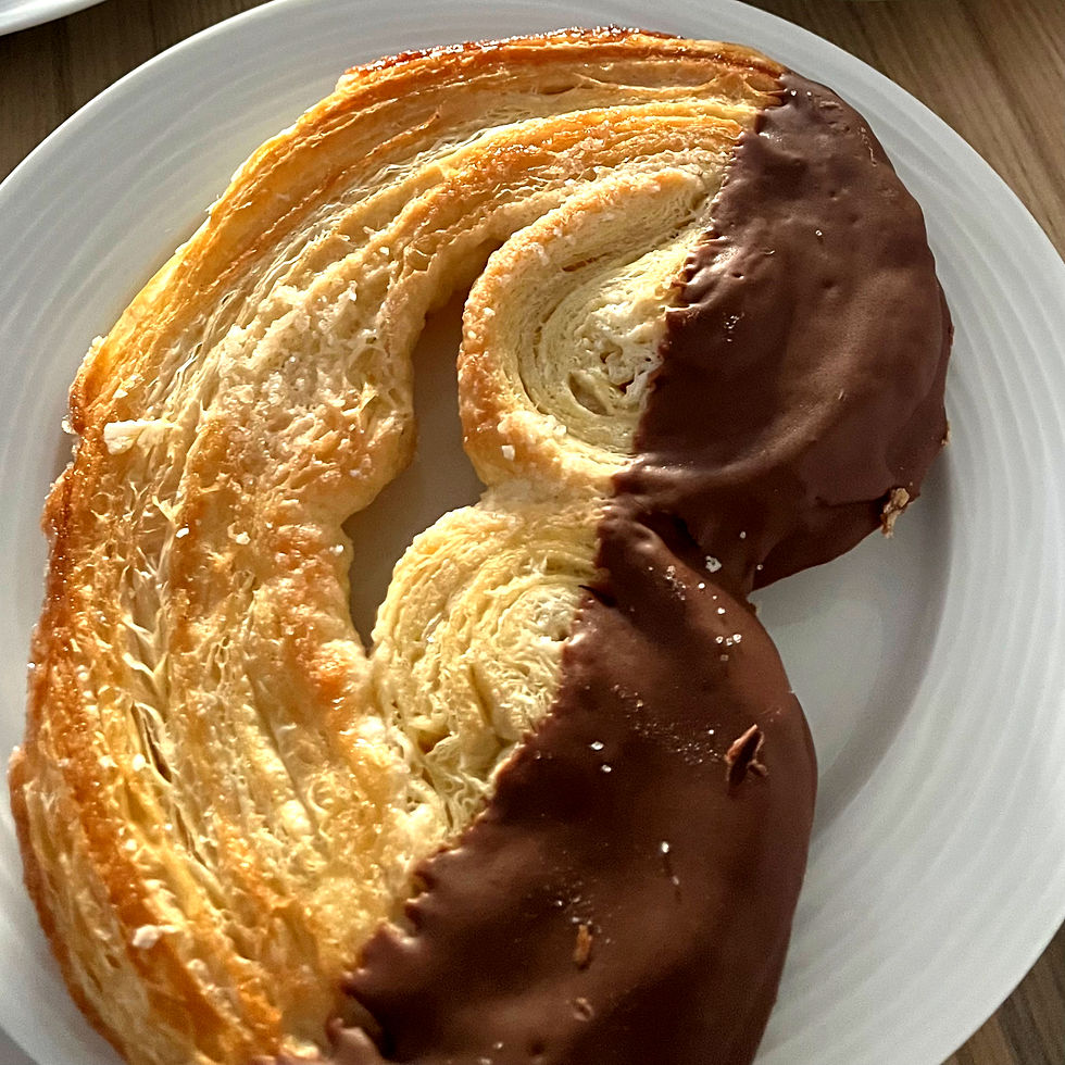 A giant chocolate-dipped palmier sits on a plate, from Lisbon Bakery in Plymouth.