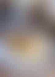 A stack of thick, fluffy pancakes are topped with fresh blueberries and drizzled lightly with honey